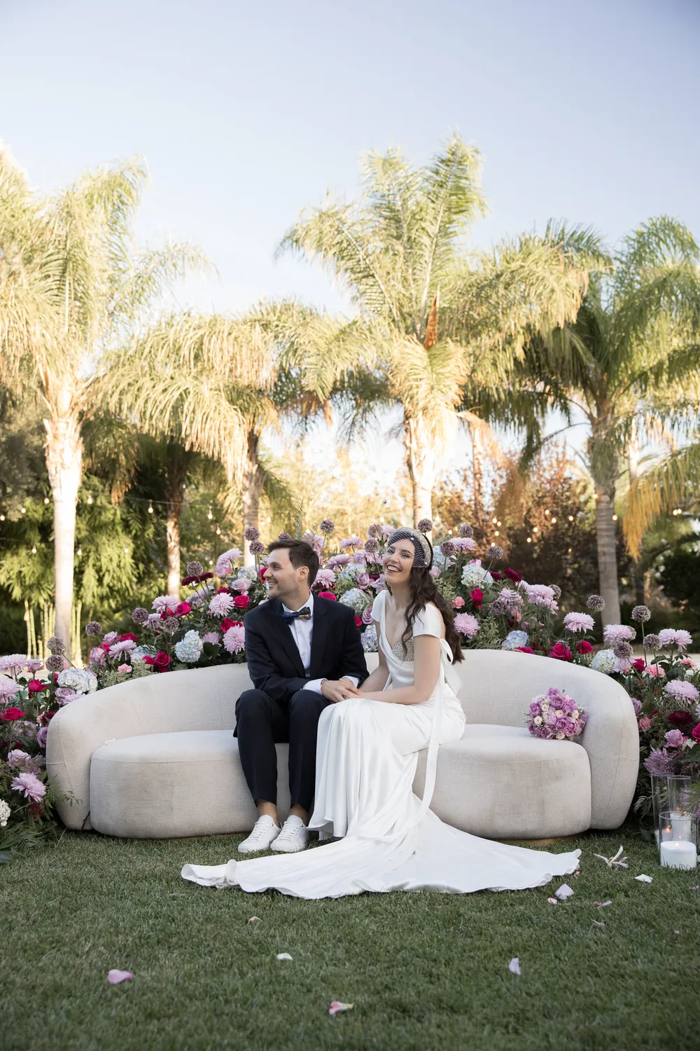 Los novios sentados entre las flores de la ceremonia
