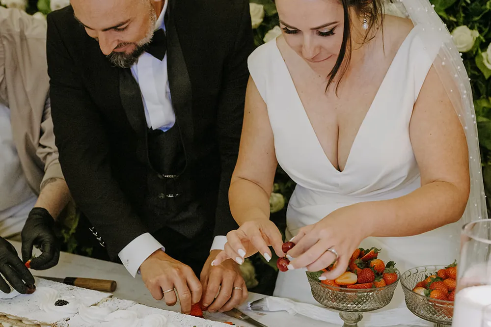 Los novios preparando la mesa de fruta del cóctel