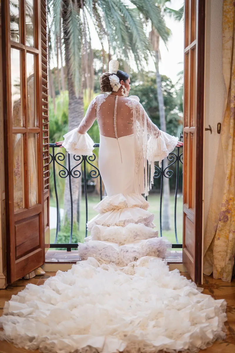 Novia asomada al ventanal antes de la ceremonia