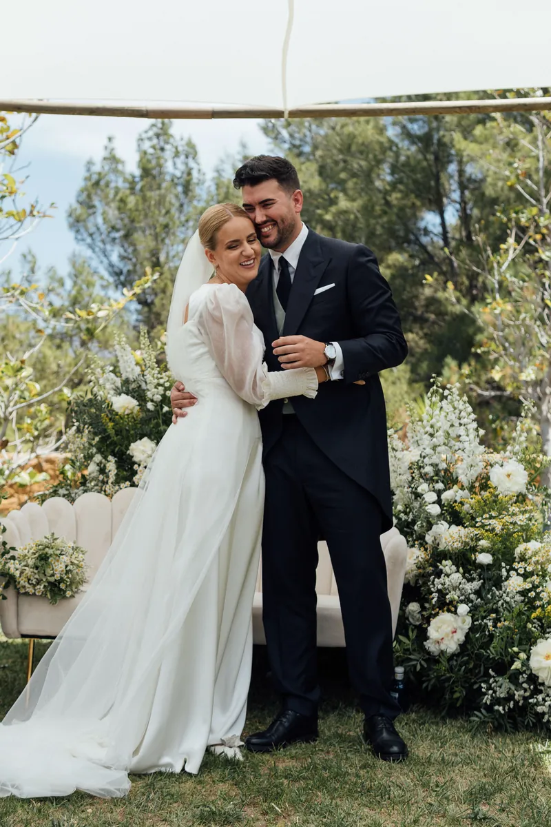 Los novios abrazados en el jardín