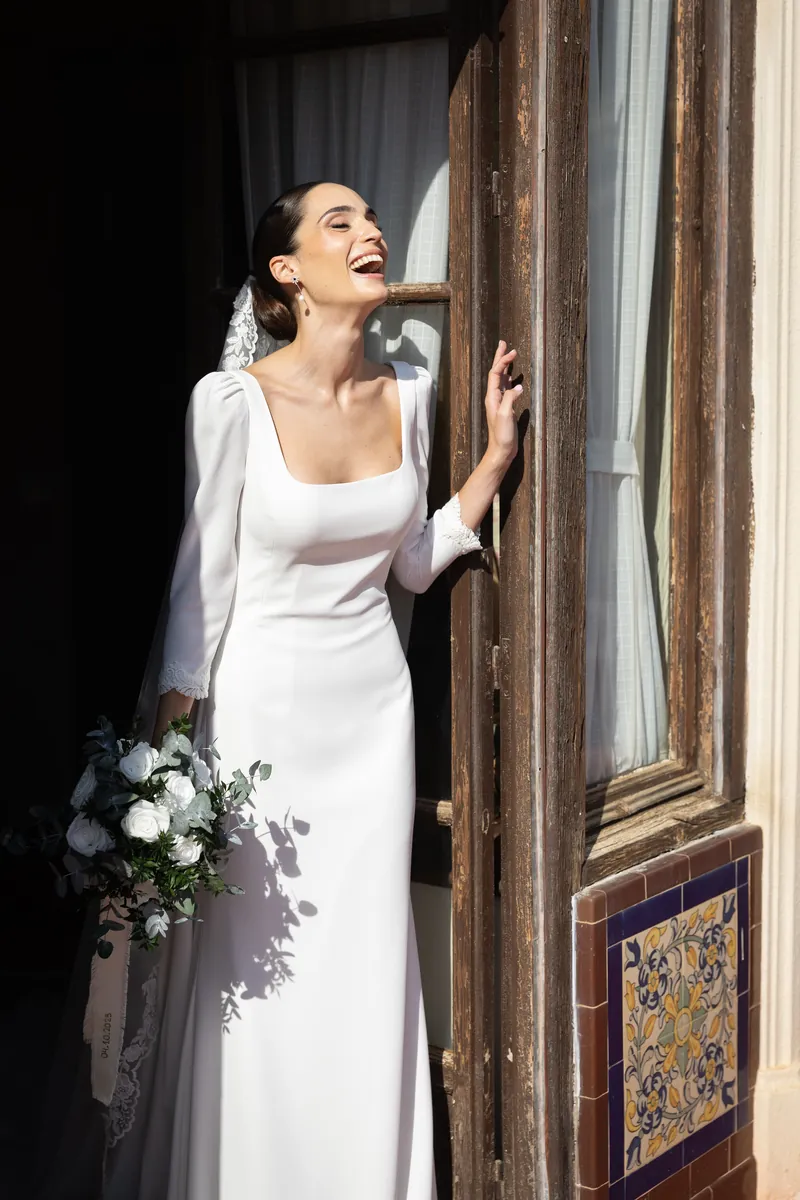 Retrato de la novia con su ramo junto a la ventana